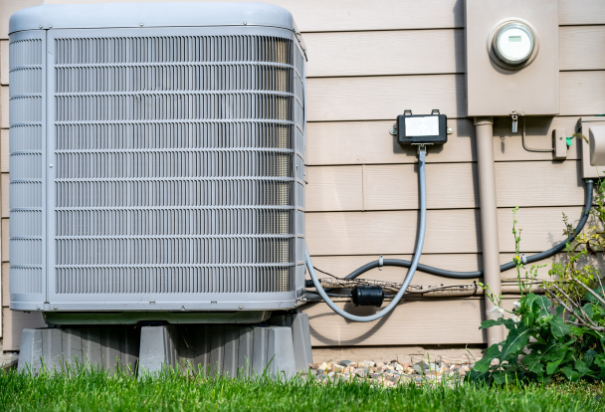Outdoor residential air conditioner installation on an elevated pad.